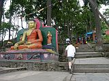 Kathmandu Swayambhunath 09 Buddha Statue Flanks Steps At Back Entrance